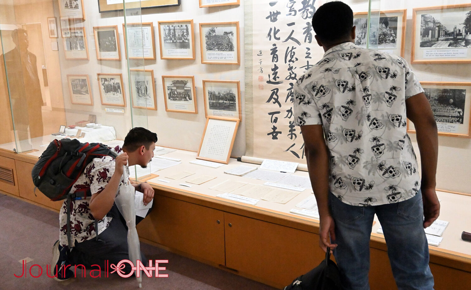 柔道の総本山・講道館内の資料館と資料を熱心に見学するアメリカ人旅行者-Journal-ONE撮影