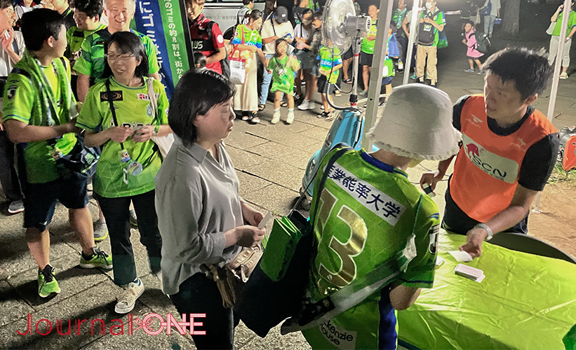 明治安田生命J1リーグ第25節の試合後、スタジアム清掃に参加するために清掃用具配布テントの前に列をなす湘南サポーターたち -Journal-ONE撮影