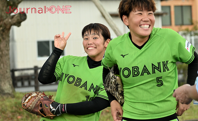 ソフトボール 全日本総合選手権|JDリーグ 伊予銀行ヴェールズの庄司奈々投手とのインタビュー中にVサインで乱入する安川裕美捕手(佐賀県白石町にて)-Journal-ONE撮影