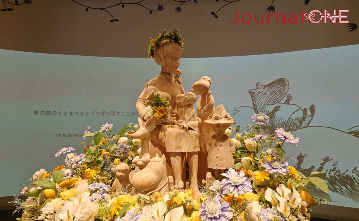 展示施設「KOKEMUS(コケムス)」内にある、原作者トーベ・ヤンソンとムーミン谷のキャラクターたちの木製彫像。周囲は色鮮やかな花々で飾られている。
