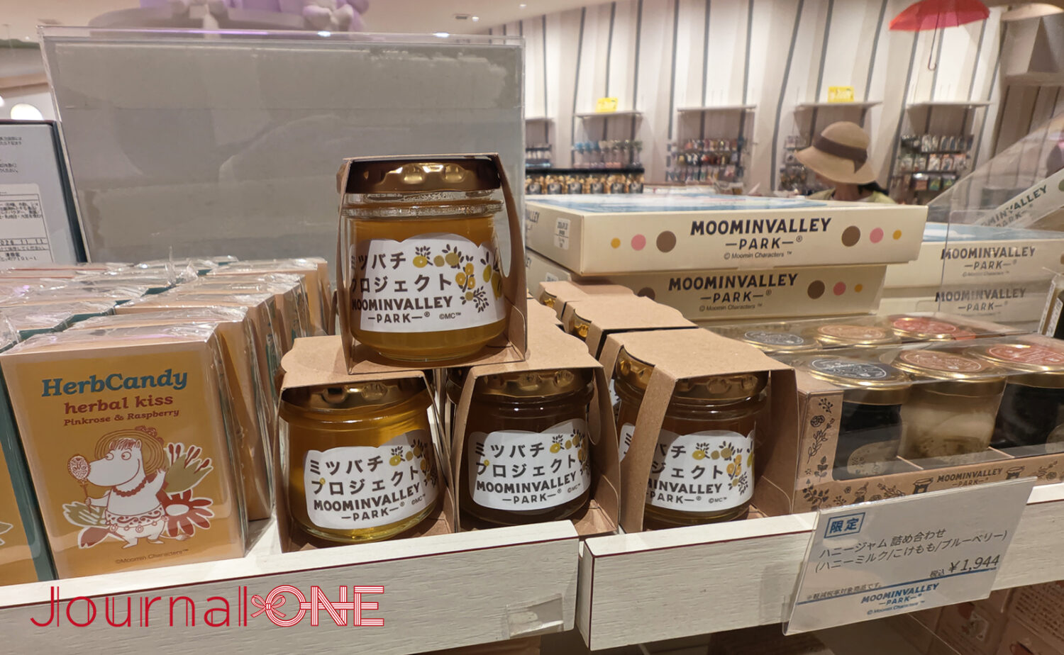 ムーミンバレーパークのショップに並ぶ「ミツバチプロジェクト」のはちみつ瓶。隣には「ハニージャム詰め合わせ」やハーブキャンディが並び、地域との共生を感じさせるお土産コーナーの様子。