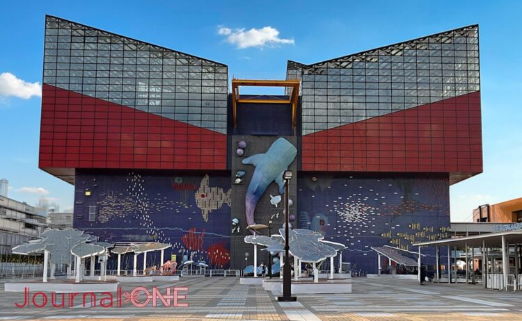 大阪港の臨海エリアにそびえる水族館「海遊館」の正面ファサード。中央の壁面には巨大なジンベエザメの立体オブジェ設置されている。