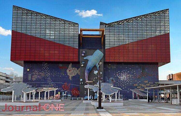 大阪港の臨海エリアにそびえる水族館「海遊館」の正面ファサード。中央の壁面には巨大なジンベエザメの立体オブジェ設置されている。