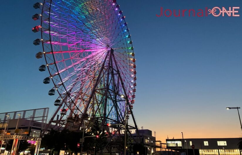 夕暮れの天保山にそびえる天保山大観覧車。カラフルなライトに彩られた巨大な観覧車が大阪港の空に浮かび上がる。