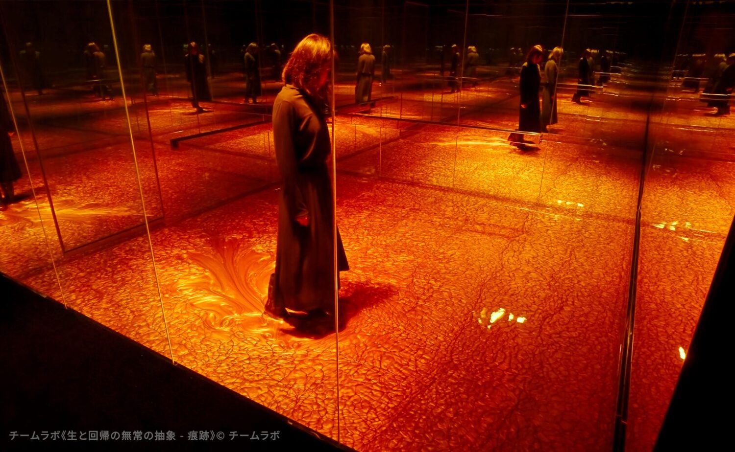チームラボバイオヴォルテクス京都内で展示されているチームラボのアート作品《生と回帰の無常の抽象 - 痕跡》。長靴を履いた鑑賞者が液体の中をゆっくりと歩み、その液体の表情の変化に没入するような幻想的な作品空間
