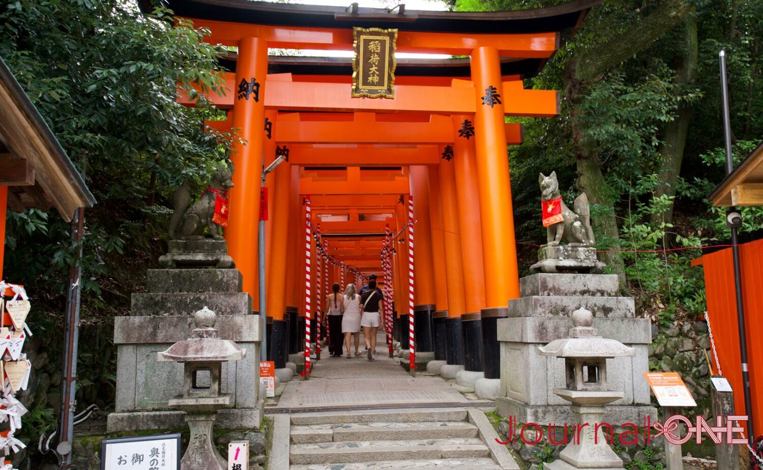 伏見稲荷大社の千本鳥居。朱色の鳥居が連なる参道を参拝者が譲り合いながら歩く