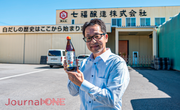 七福醸造の工場前に立つ犬塚元裕社長